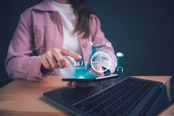 247 guest support Businesswoman holding smartphone showing virtual 24/7 with clock. Worldwide nonstop and full-time available contact of service. Nonstop service, Care and consulting client 24hr customer service.